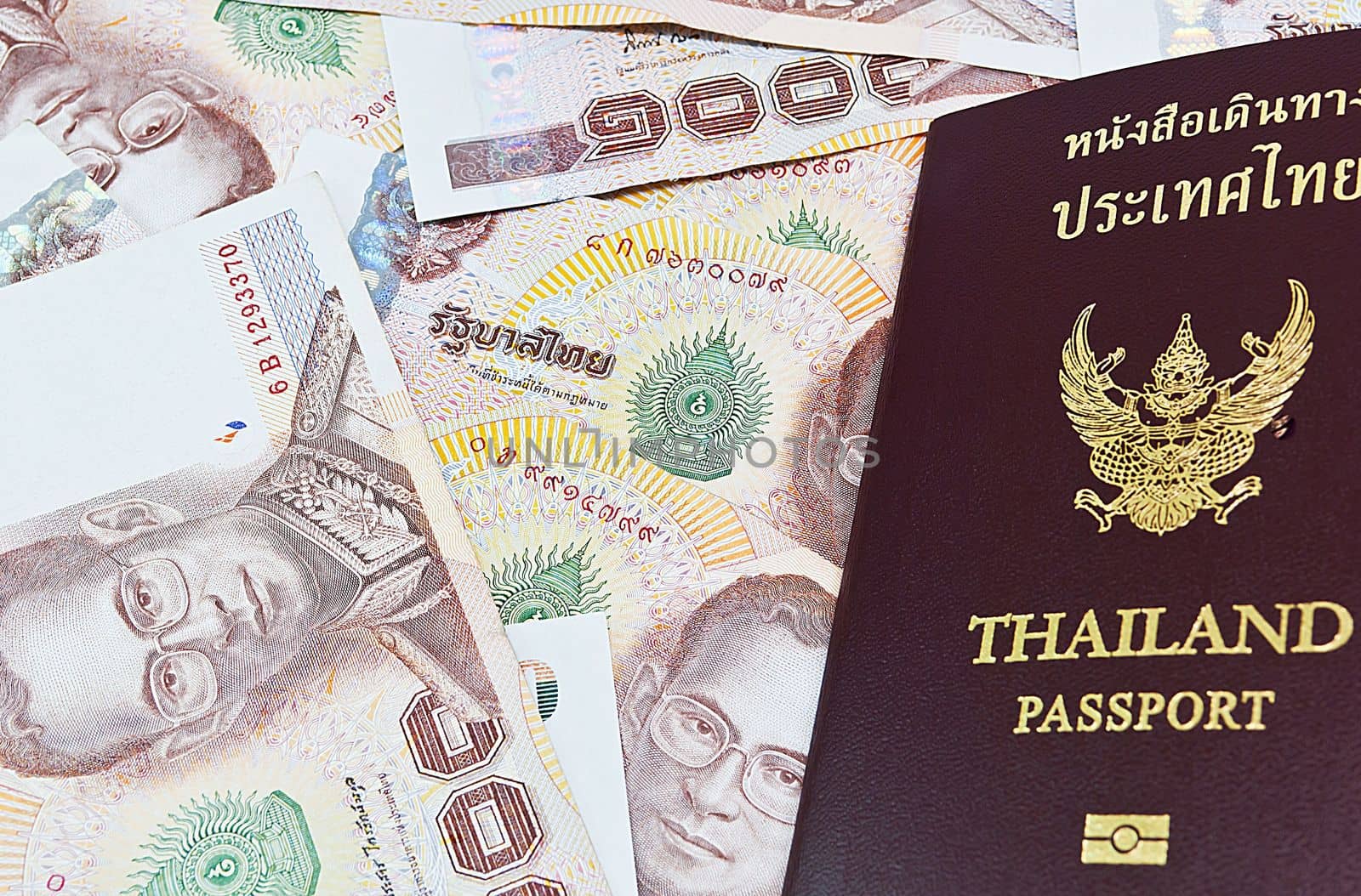 Thailand passport with Thai money ready to travel on white background