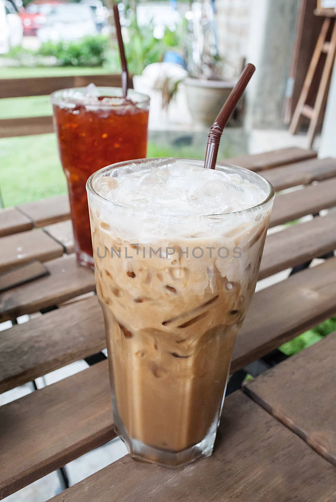 Glass Of Cold Coffee With Milk On Wooden Table for Summertime, selective focus