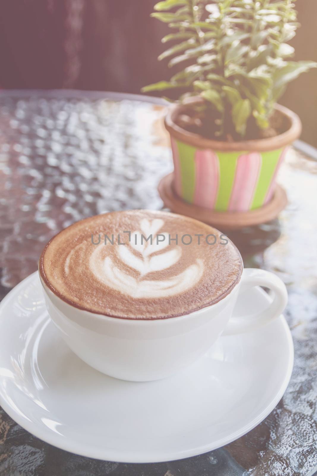 Closeup of white cup with hot latte art on glass table  by rakoptonLPN
