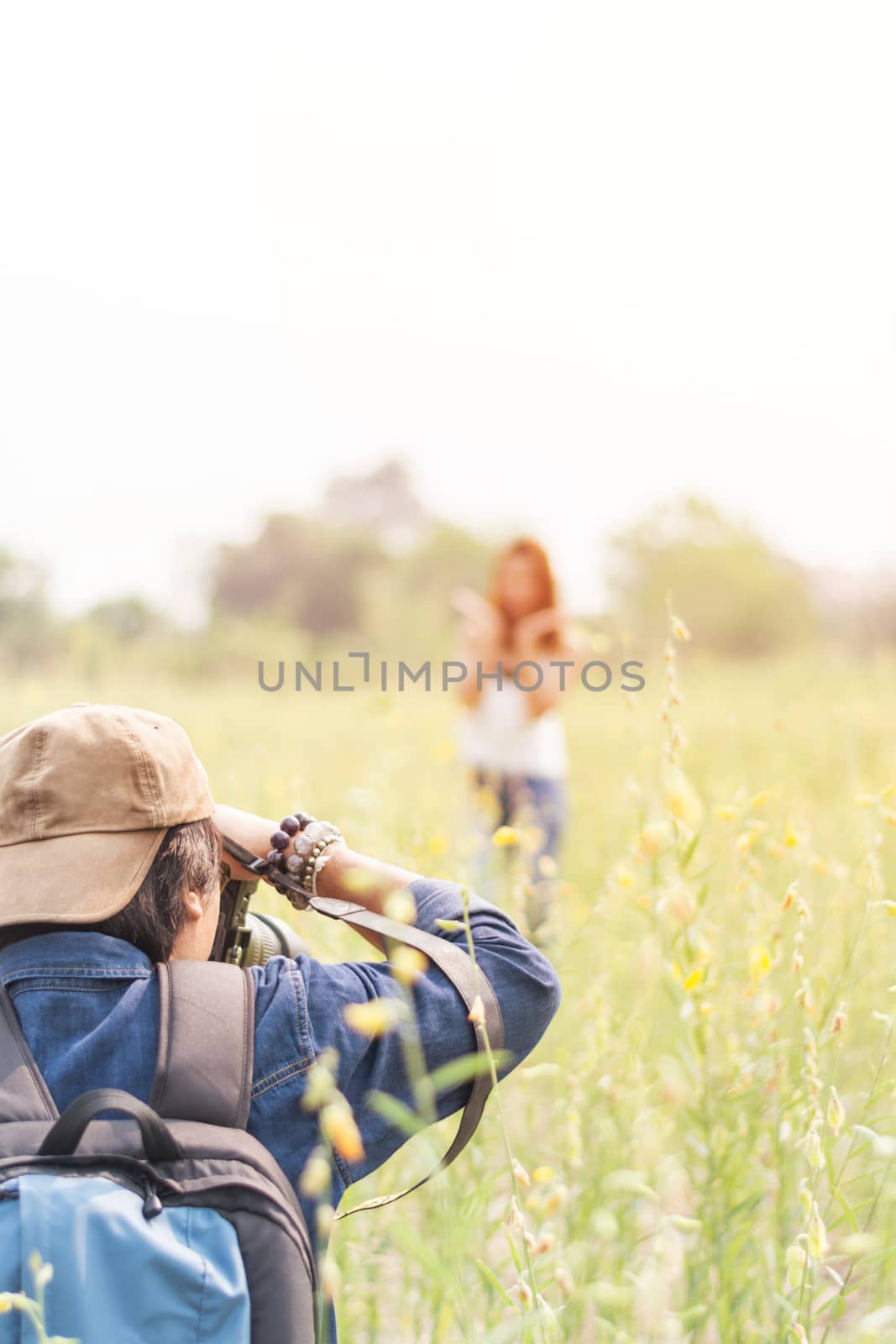 Man photographing young beautiful woman against in green field attractions, Summer time, outdoors, portrait of young couple in outdoors