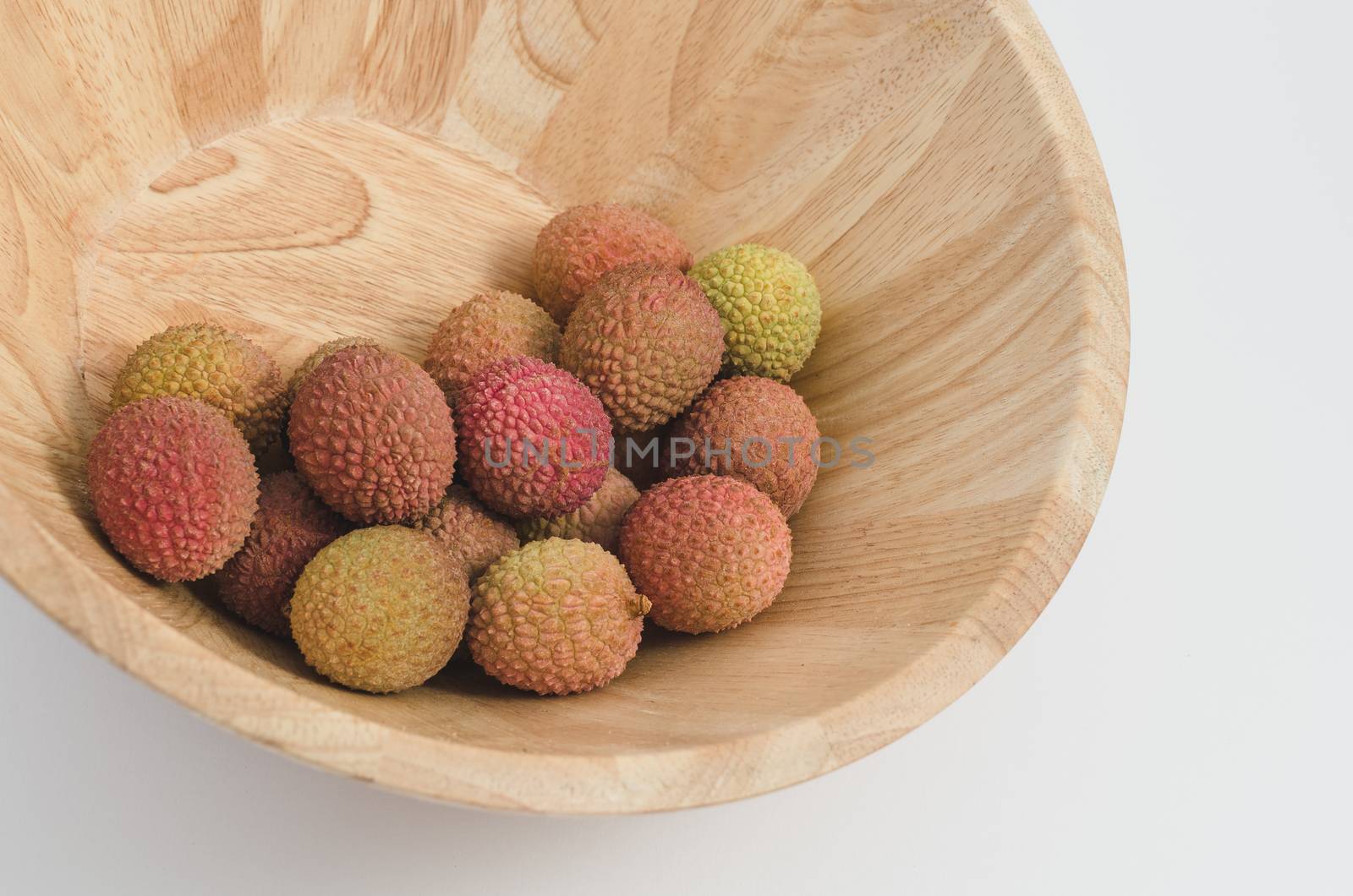 lychee fruit in a wooden bowl, white background