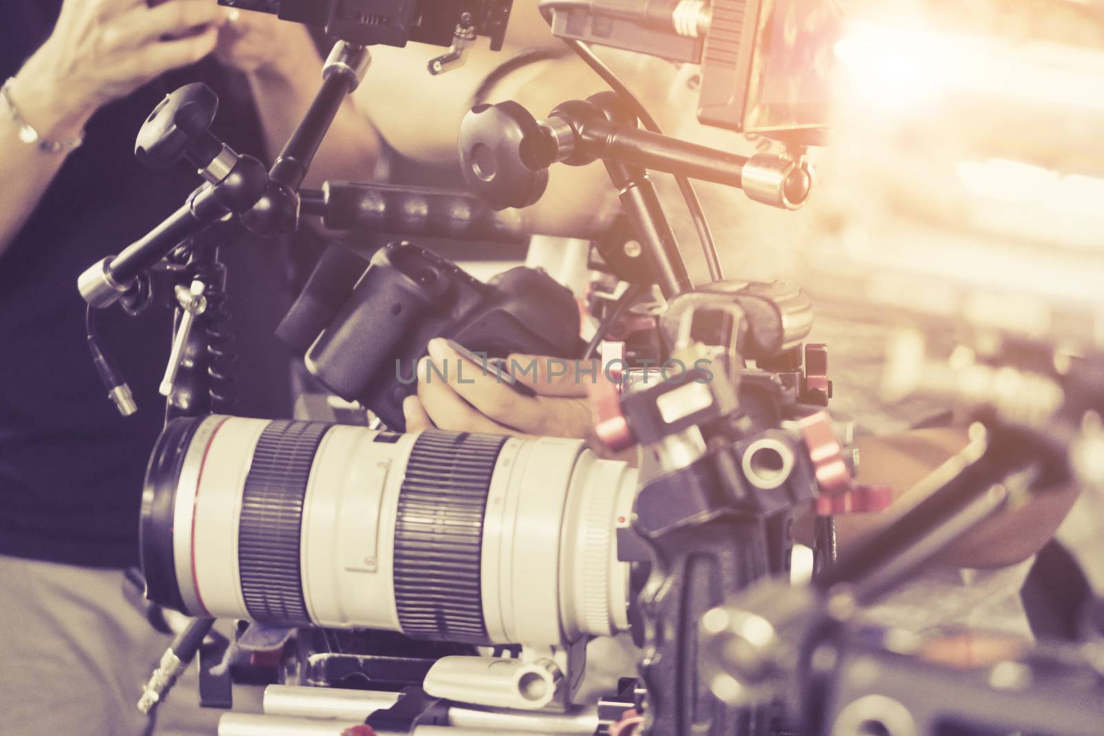 Cameraman with his video camera shooting, Hands Adjusting Camera,film production crew, behind the scenes background.