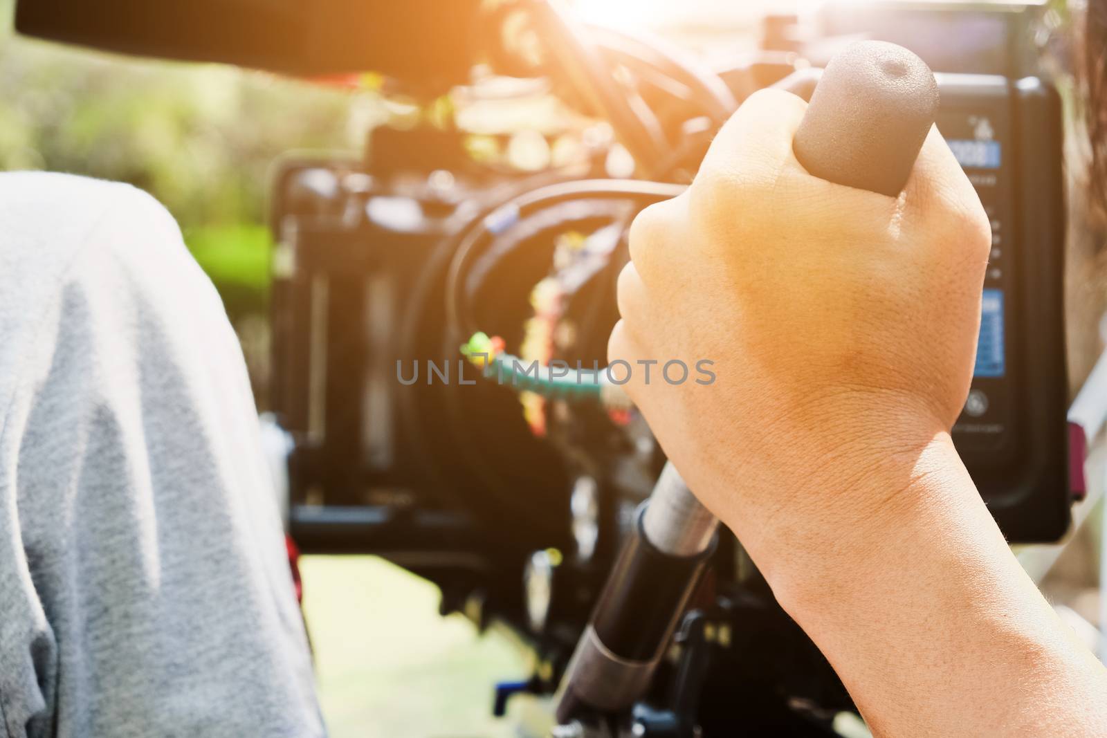 Cameraman with his video camera shooting, Hands Adjusting Camera,film production crew, behind the scenes background.