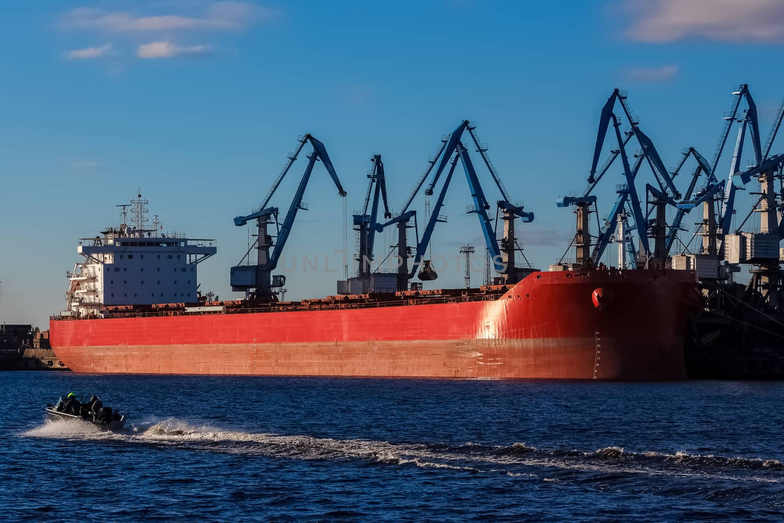Red cargo ship loading in the port of Riga, Europe