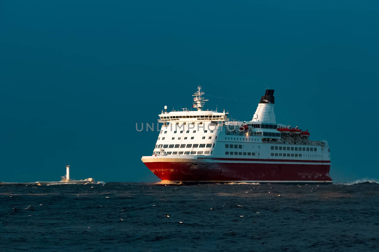 Red cruise liner. Passenger ship sailing from the sea in the morning