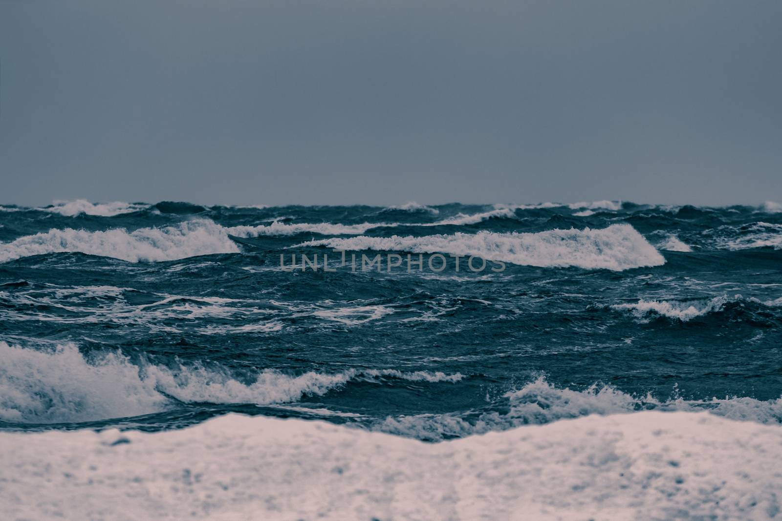 Big waves at the sea in stormy weather. Toned dark blue