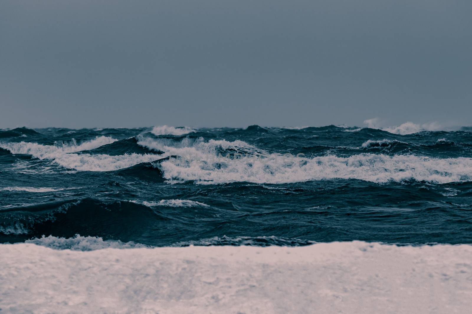 Big waves at the sea in stormy weather. Toned dark blue
