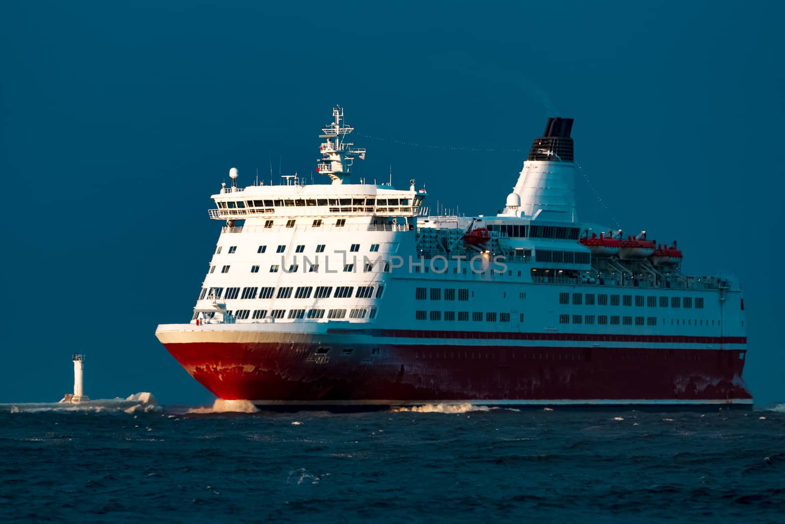 Red cruise liner. Passenger ship sailing from the sea in the morning