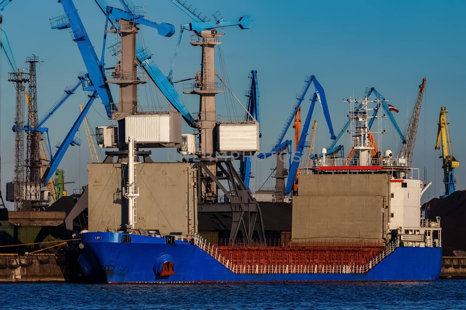 Blue cargo ship loading in the port of Riga, Europe