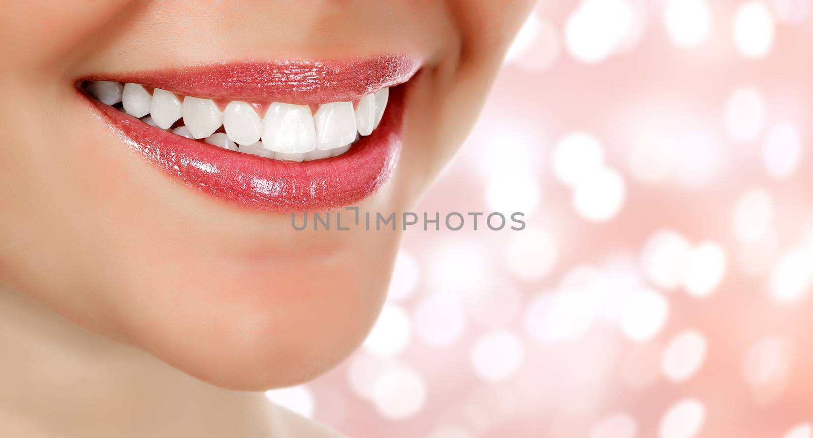 Picture of woman's smile against an abstract background with blurred lights