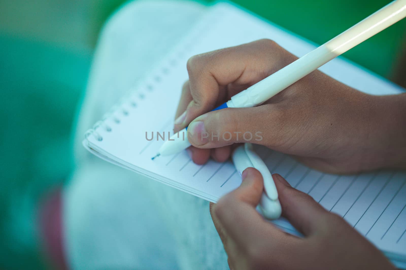 Close-up of female hand holding a pen and writing some research notes in the appointment book