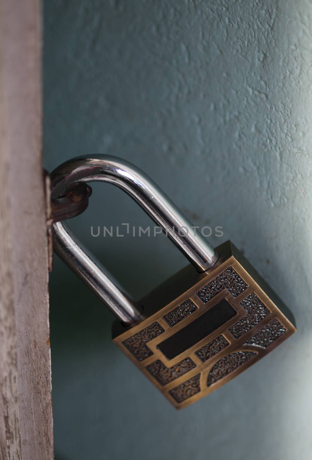 COLOR PHOTO OF CLOSE-UP OF LOCKED METAL PADLOCK