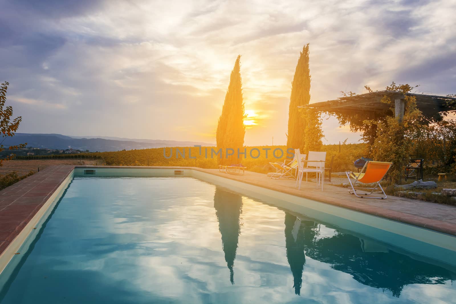 sunset over a pool in italian countryside