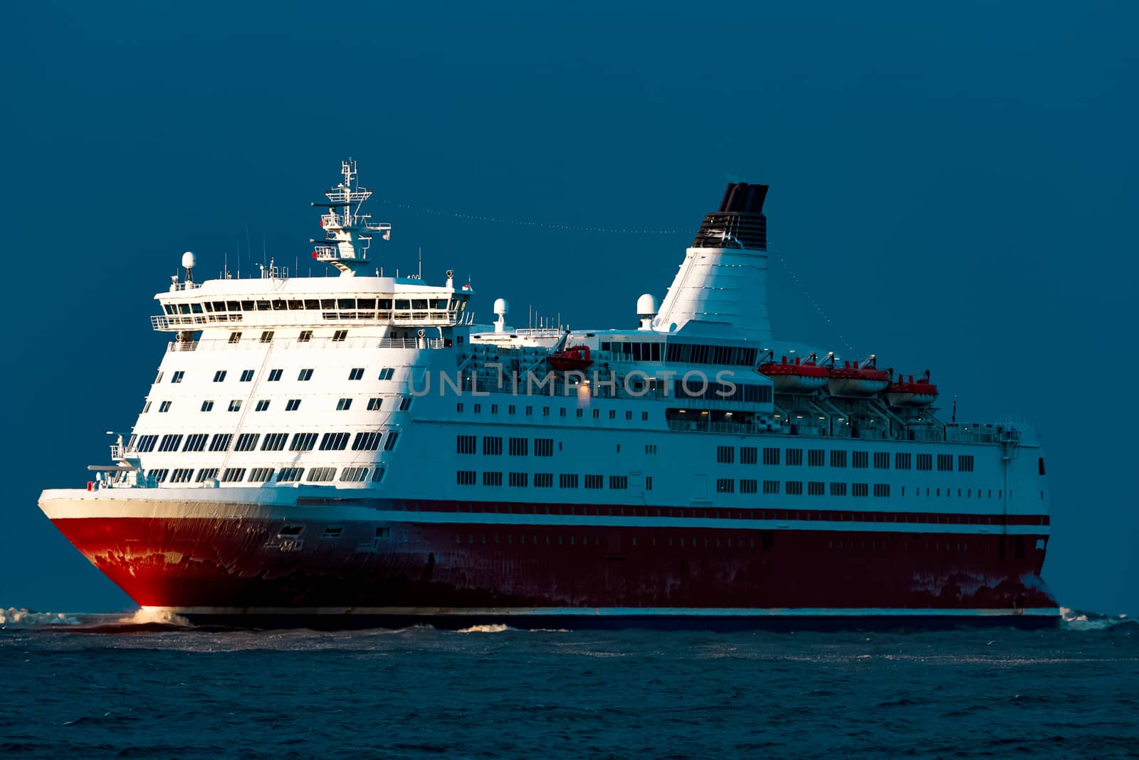 Red cruise liner. Passenger ship sailing from the sea in the morning