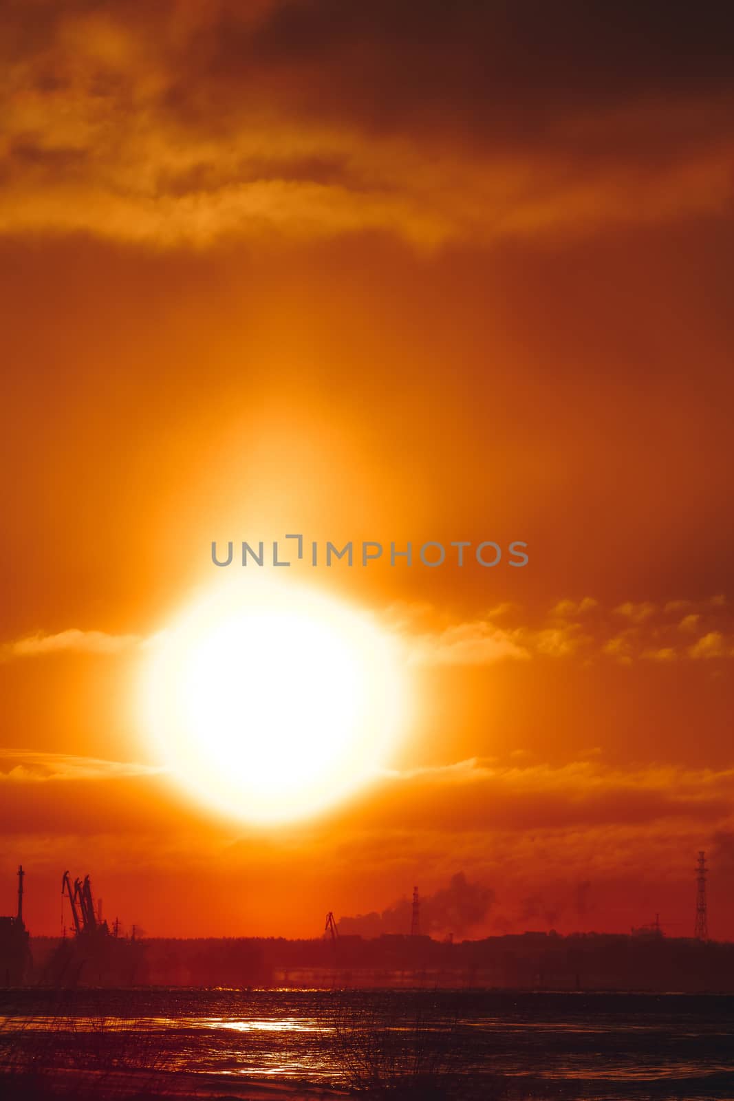 Hot orange winter sunrise against the cargo port