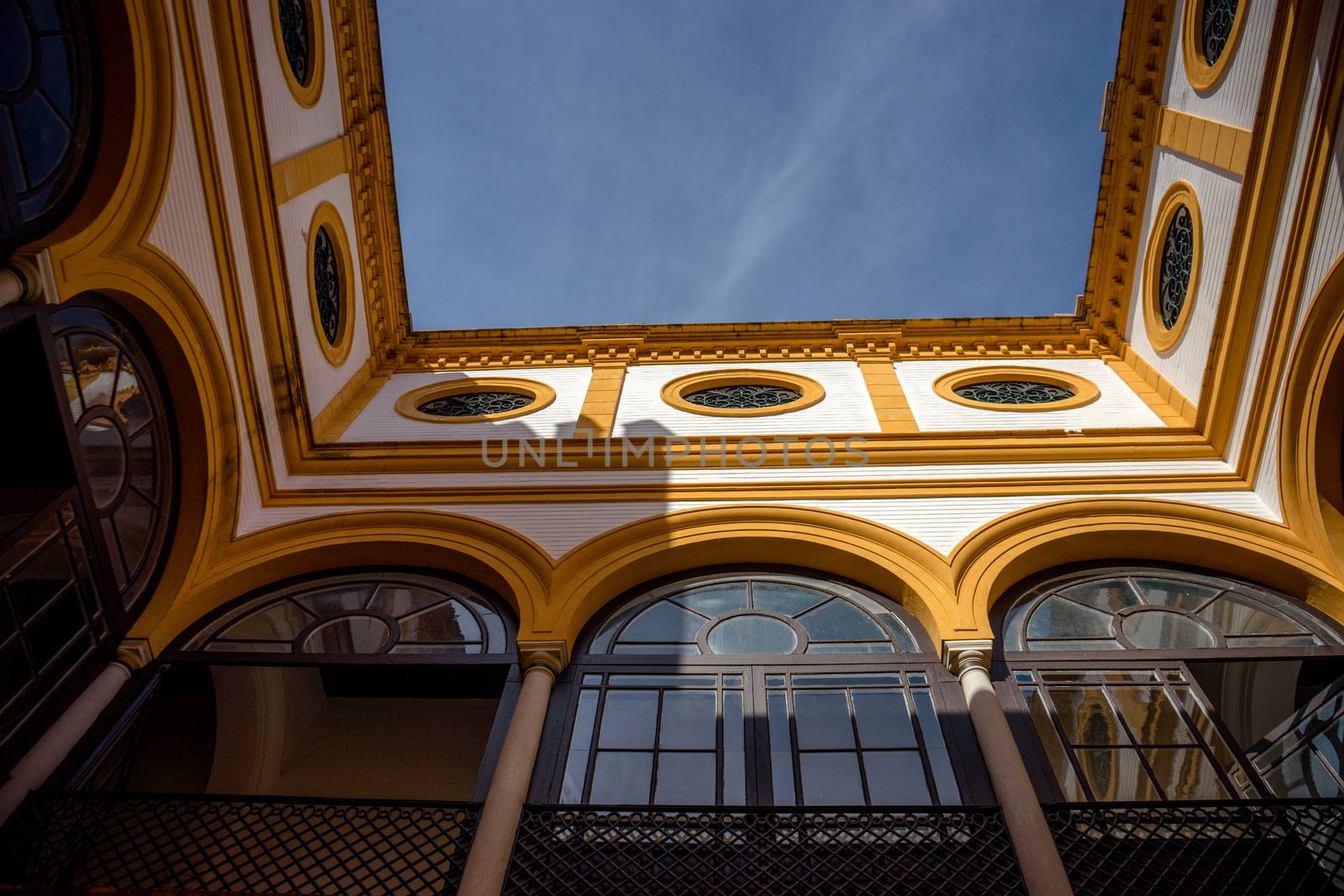 Yellow arch of a balcony against a blue sky in Seville, Spain, Europe