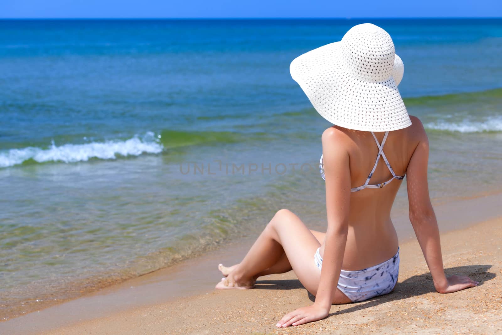 Woman in big straw sunhat sunbathing on a sandy beach. Summer ho by Nobilior