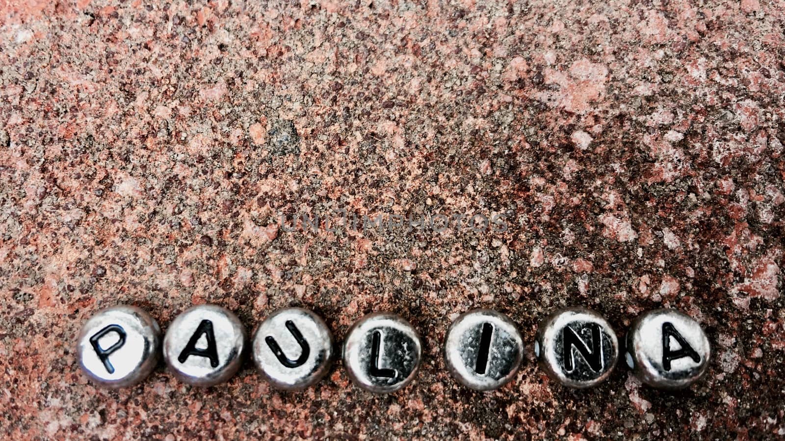 Small silver separate letters paulina inscription on dirty and old background.