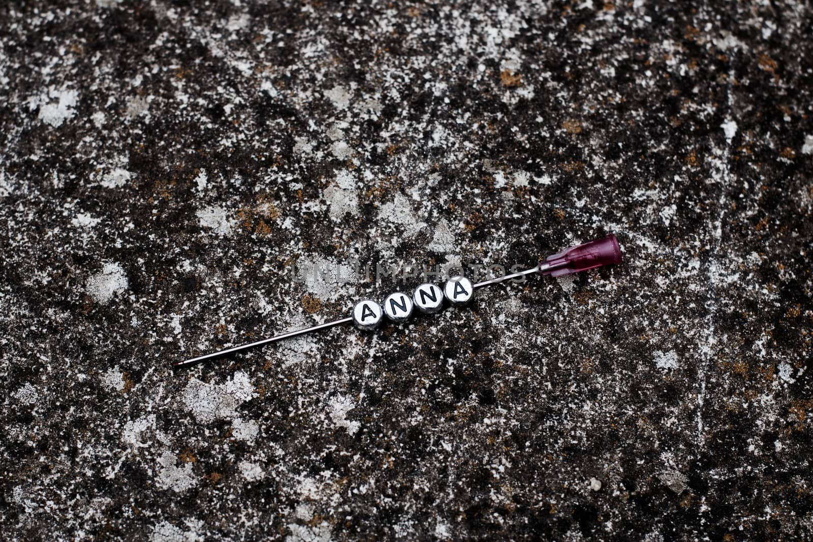 Silver letters. Anna polish name on the needle on the dirty background.