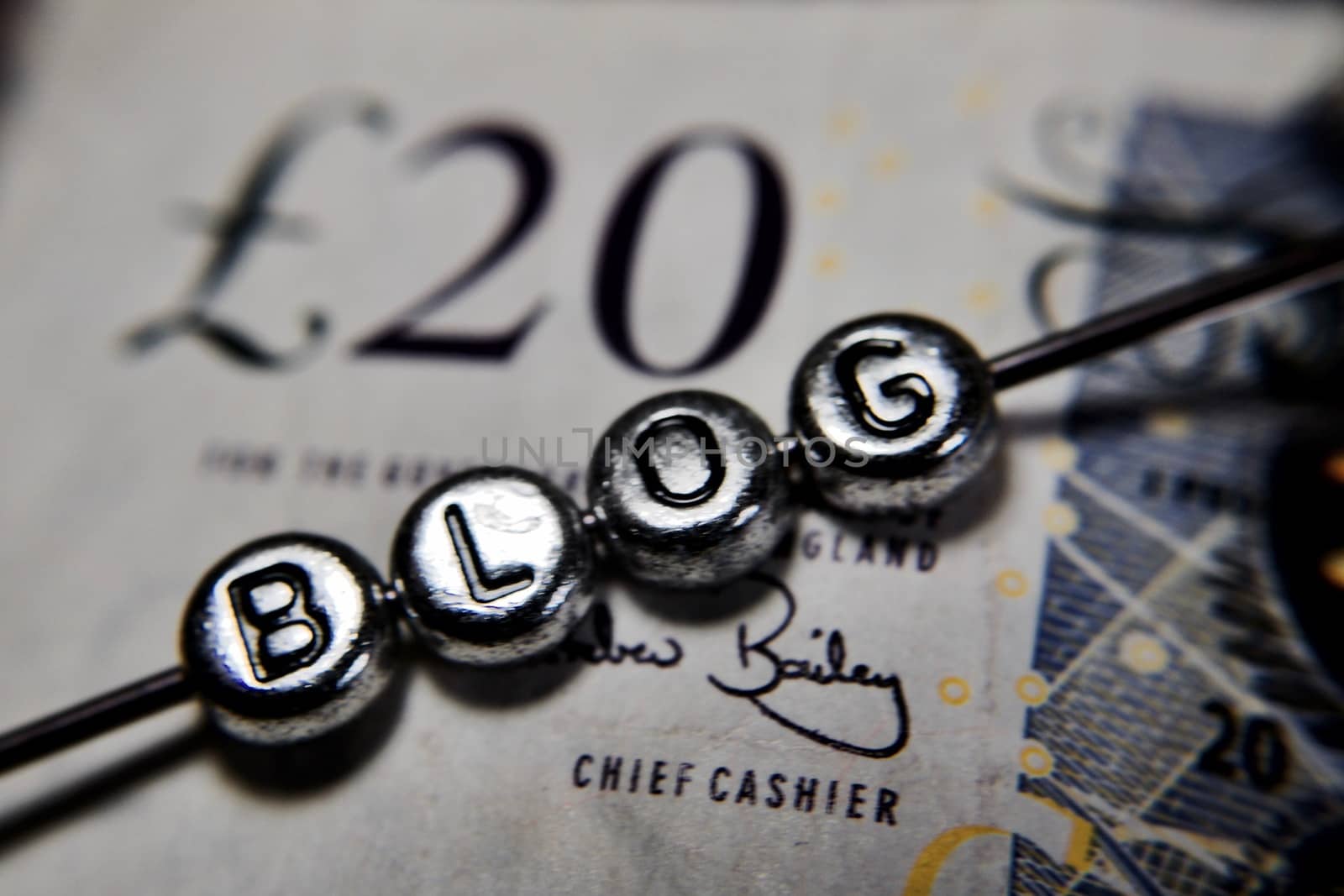 Silver letters blog on the twenty british pounds paper. Blog finance.