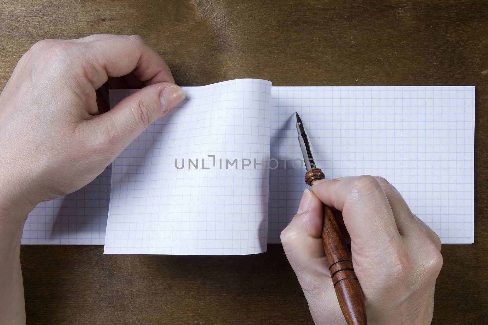 Hand writing in a note book on a wooden background