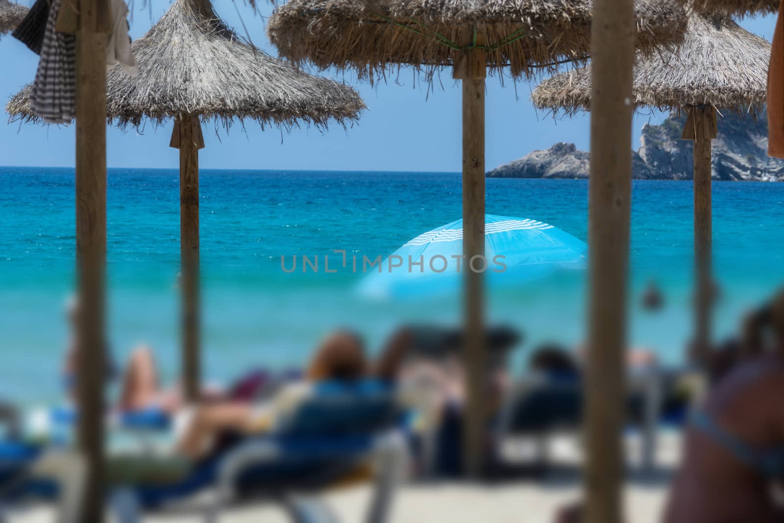 Beach life, holidaymaker at the beach bottom part of the image desired blur. Focus above composition overlooking the sea.