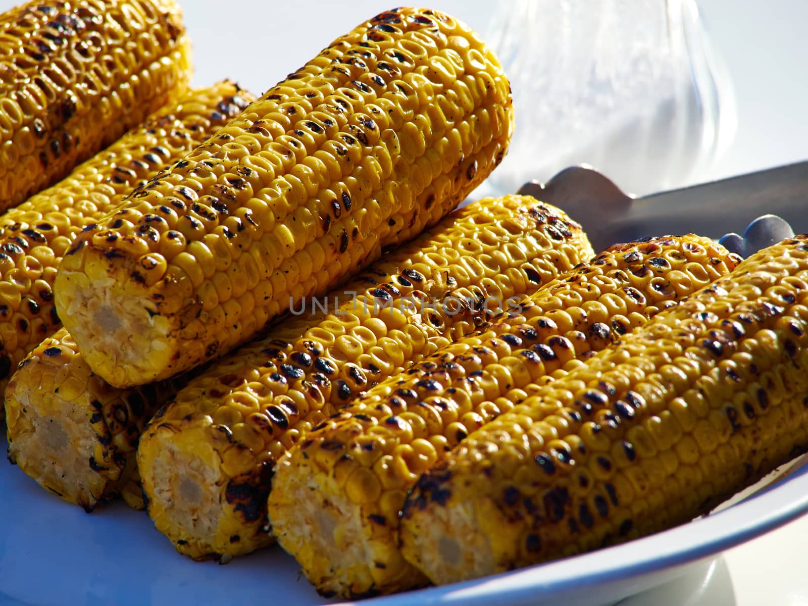 Fresh roasted or grilled corn cobs for sale in a food market  