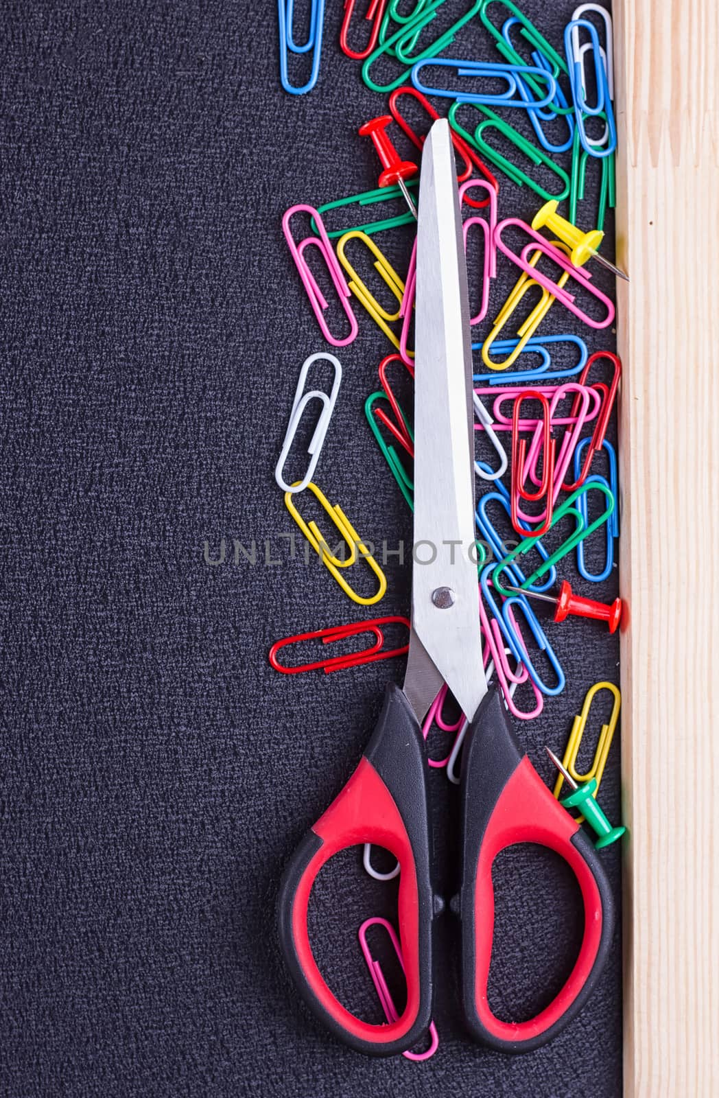Scissors and paper clips on a black background