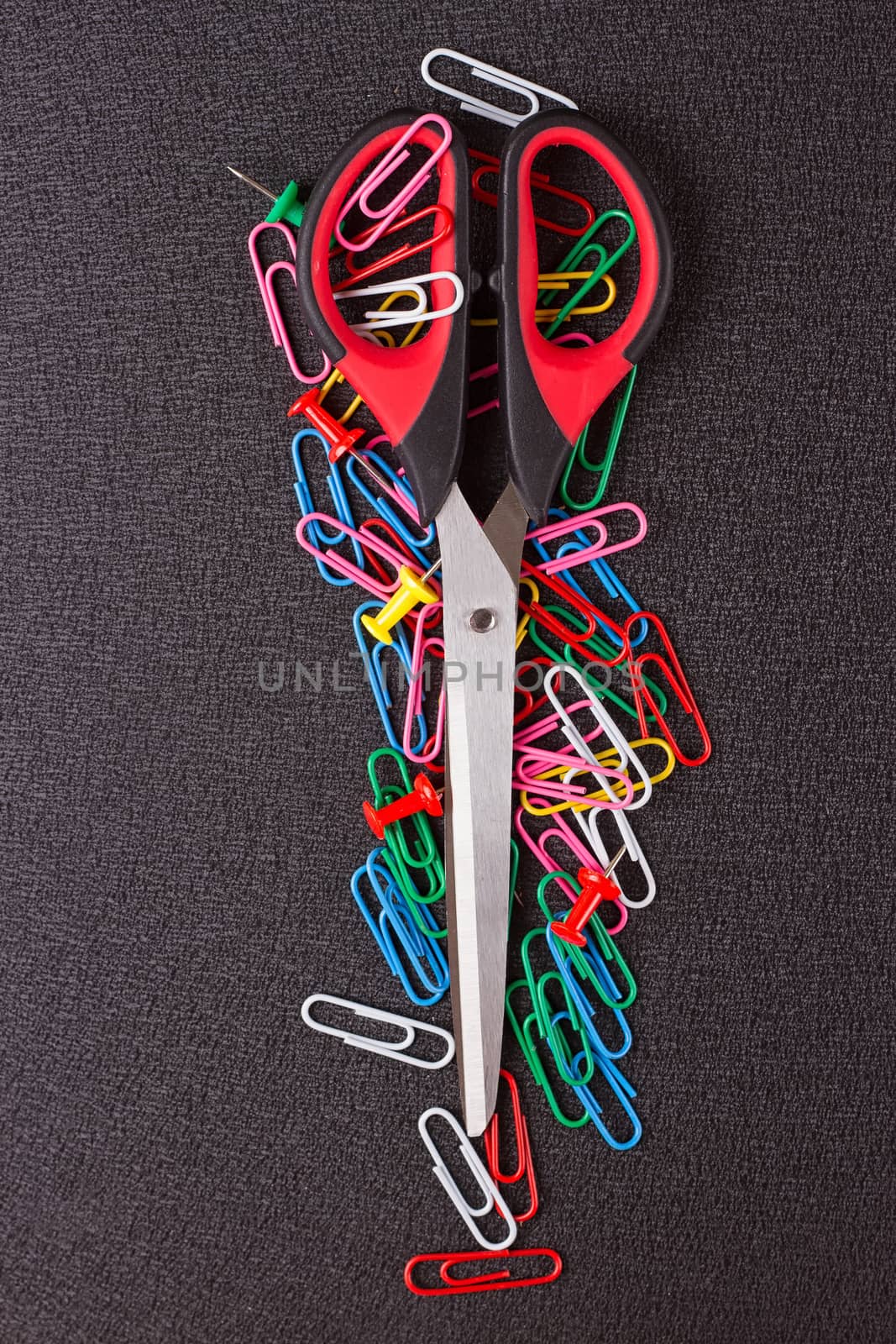 Scissors and paper clips on a black background