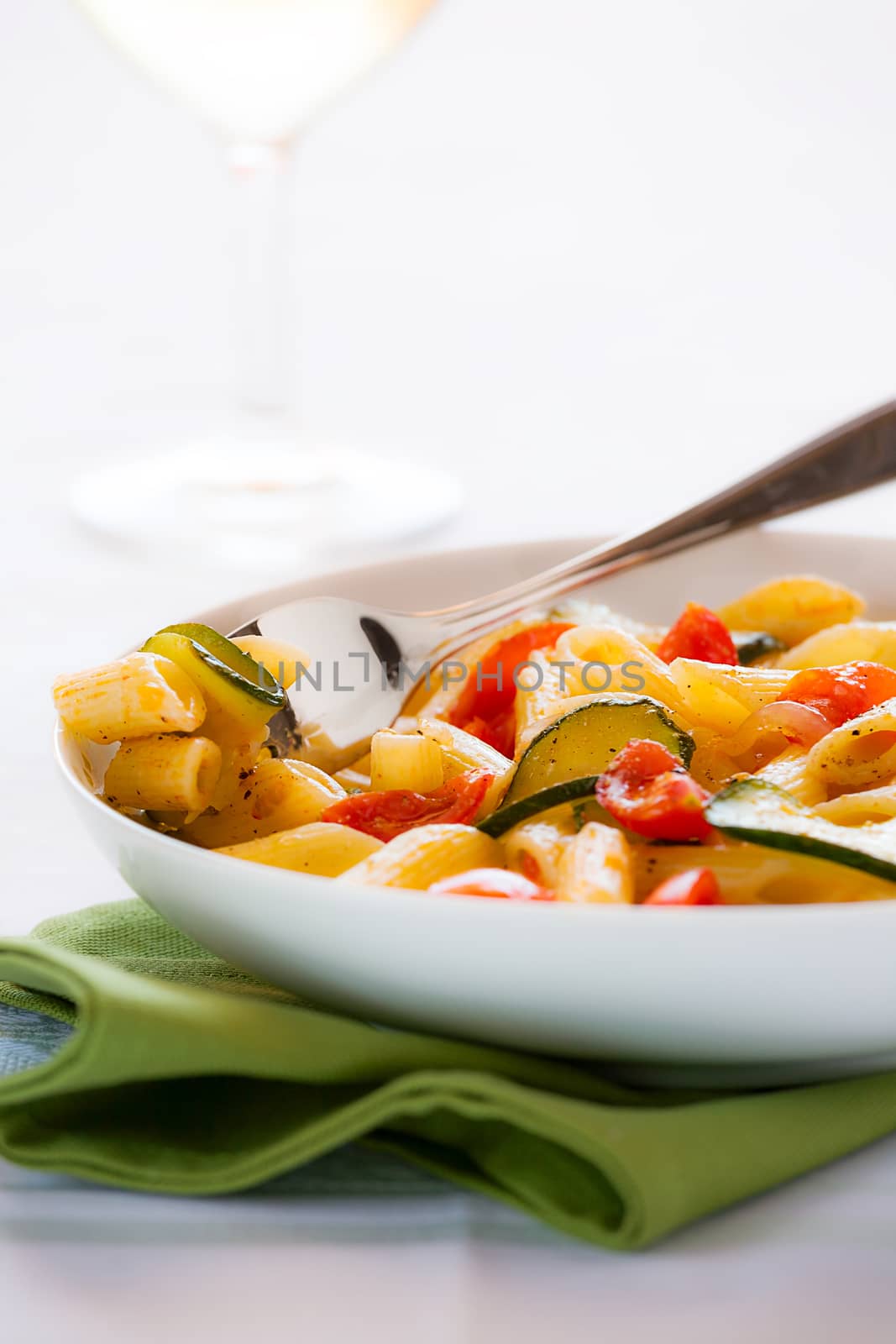 Traditional italian penne pasta with zucchini and cherry tomatoes ready to eat