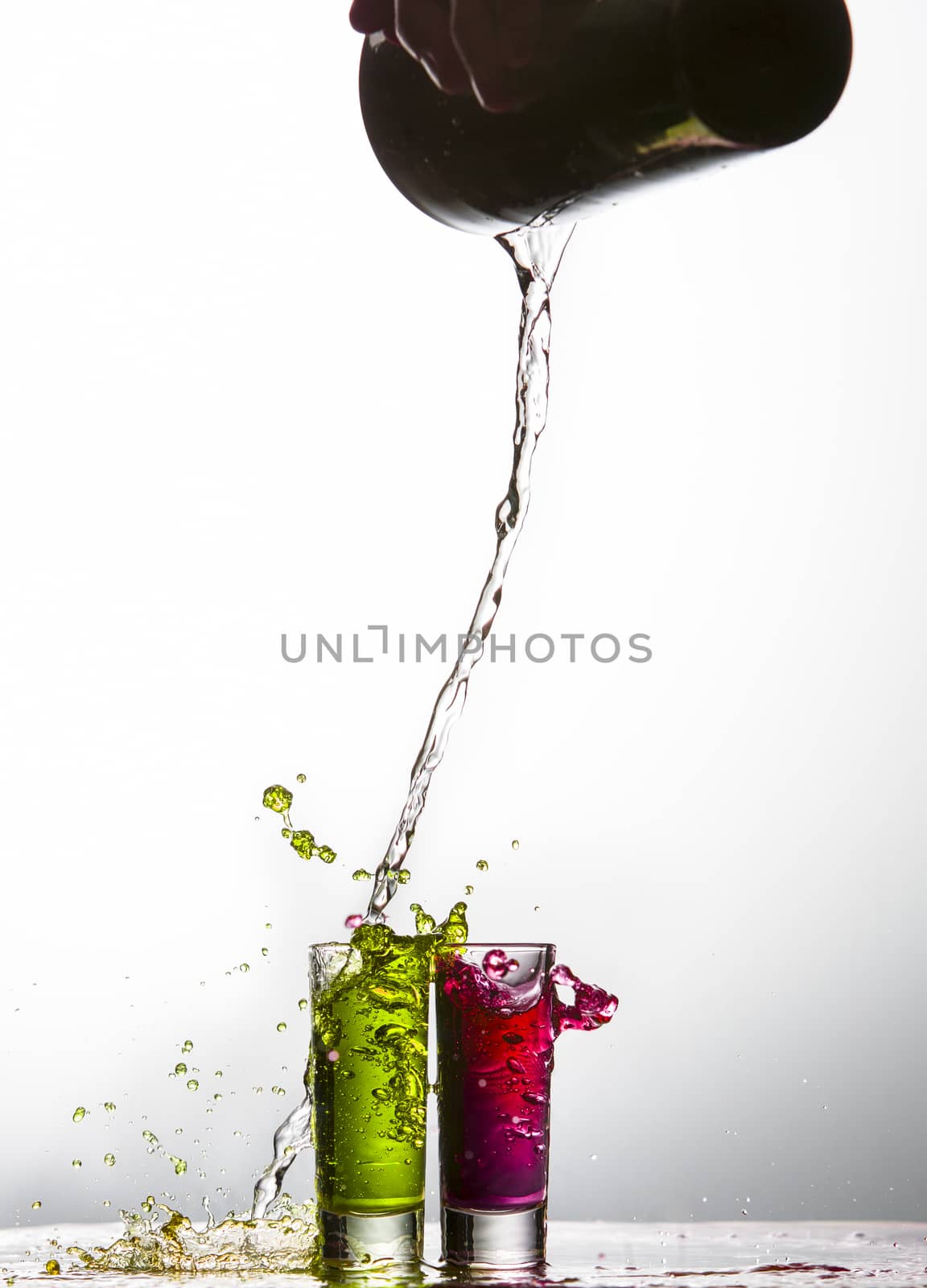 Liquid pouring into shot glasses by Njean