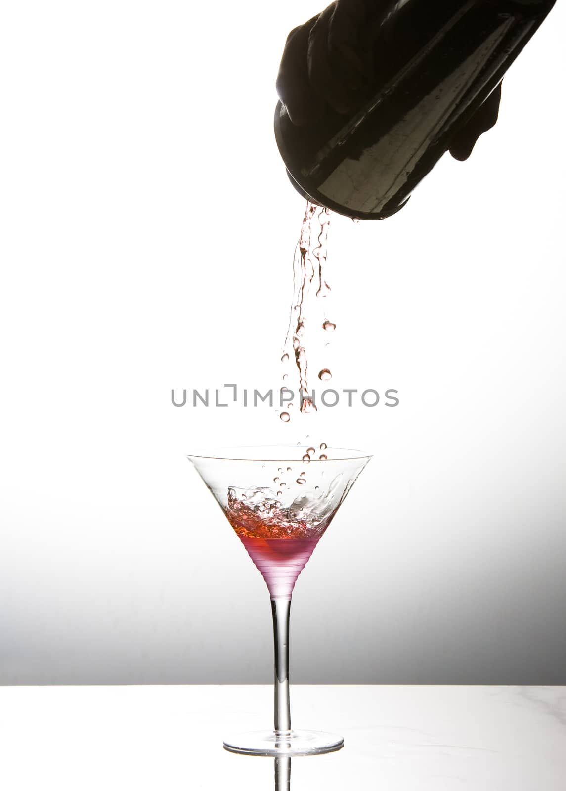 Cocktail being poured into martini glass