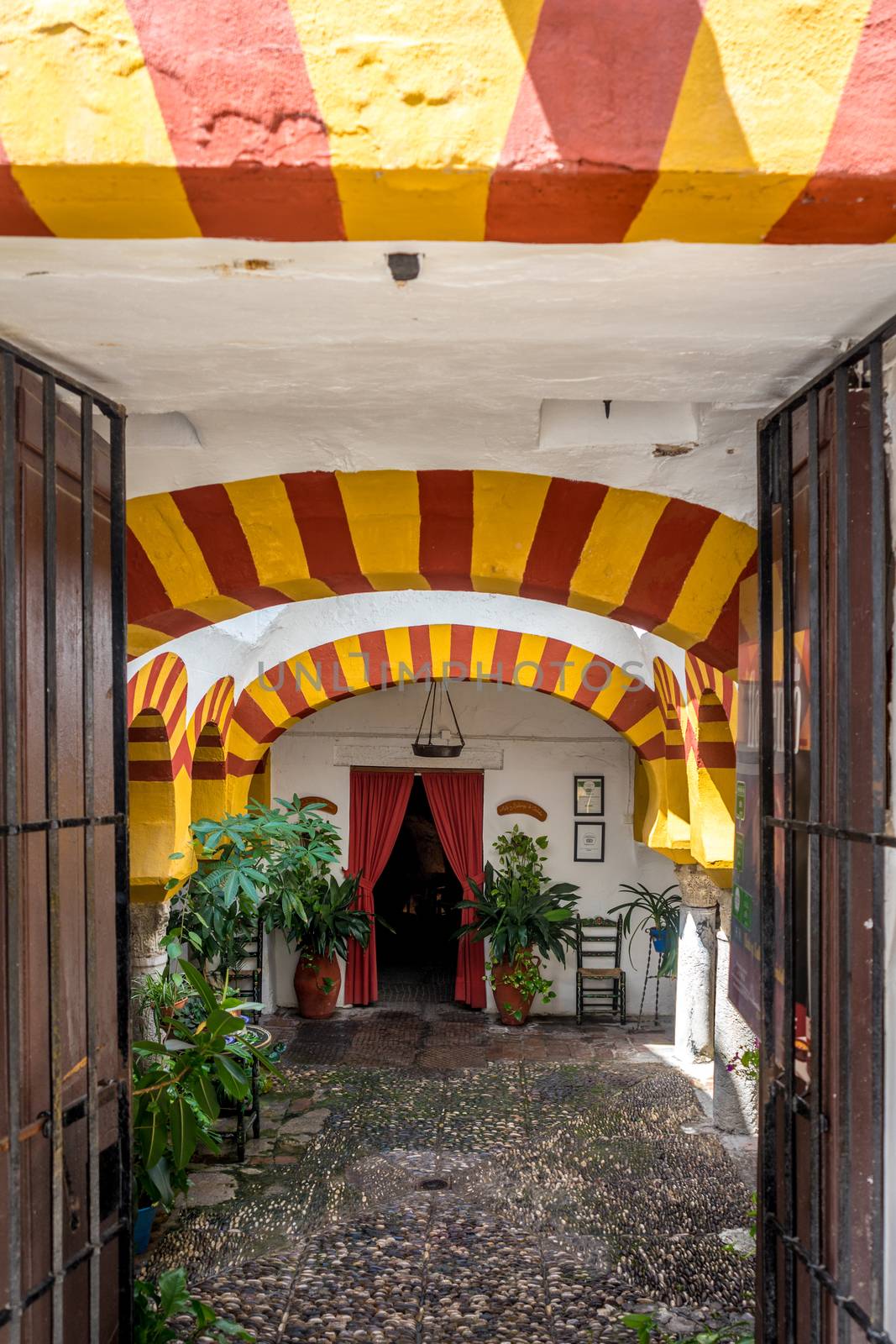 Yellow arches at Entrance to a restaurant with red curtains in Cordoba, Spain, Europe