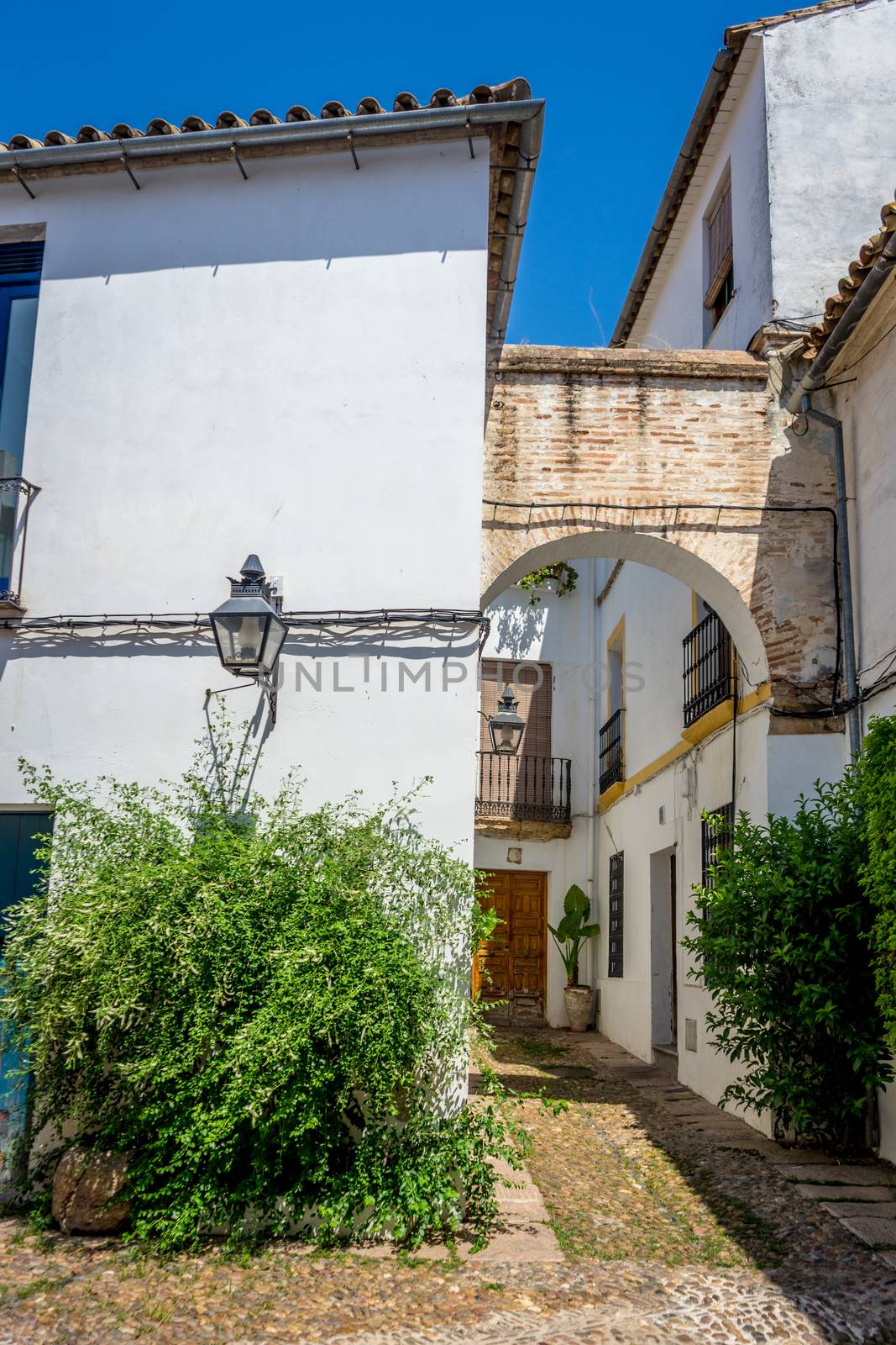 Cordoba, Spain - June 20 : An Arch on The empty streets of Cordoba on June 20, 2017 on a bright summer day with blue sky.