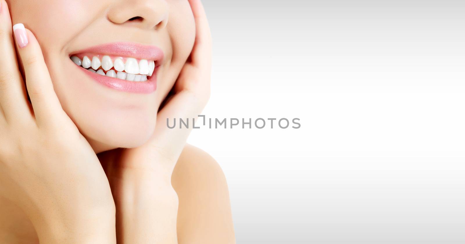 Closeup shot of happily laughing pretty woman against a grey background with copyspace