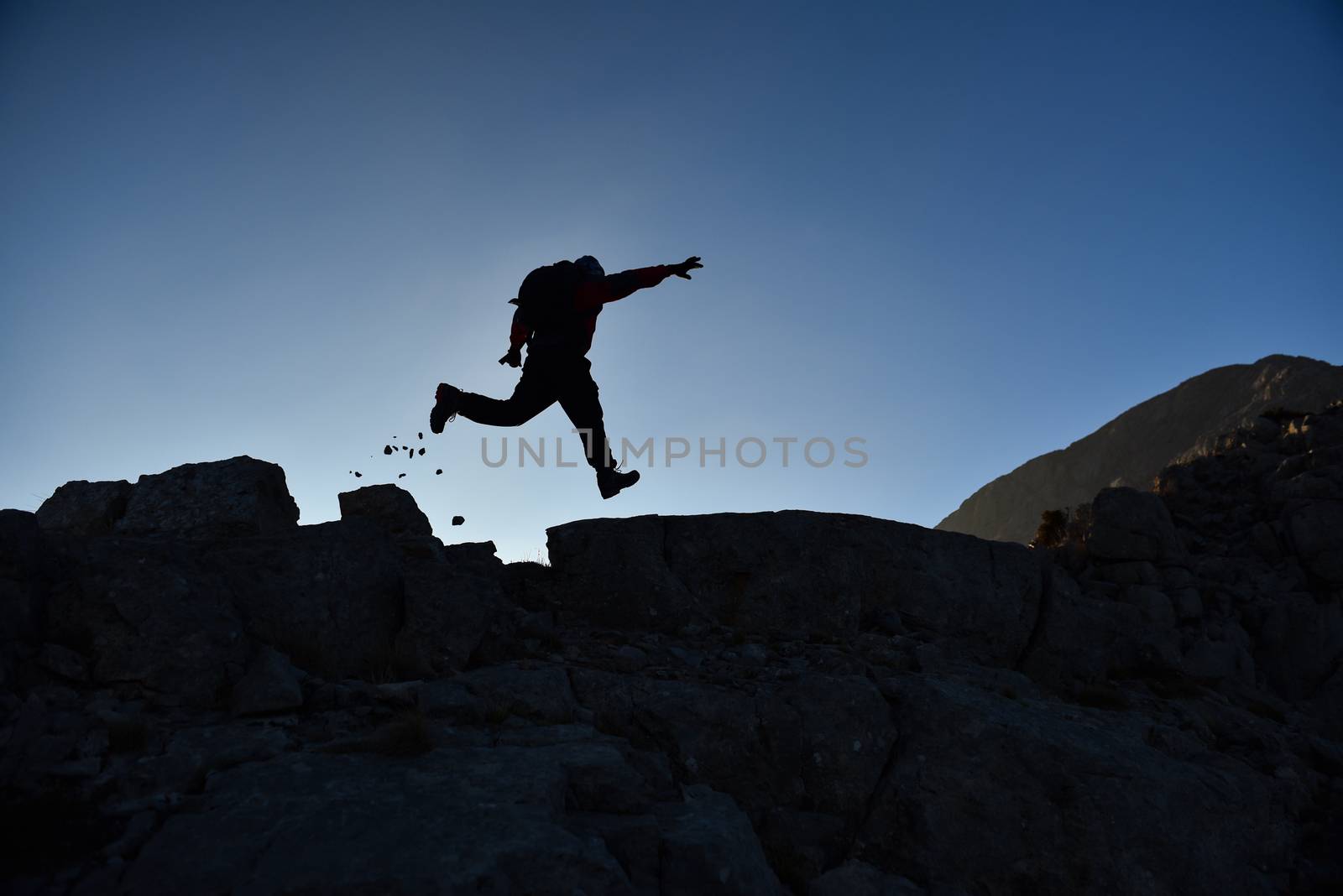 dynamic summit climber in the rocks by crazymedia007