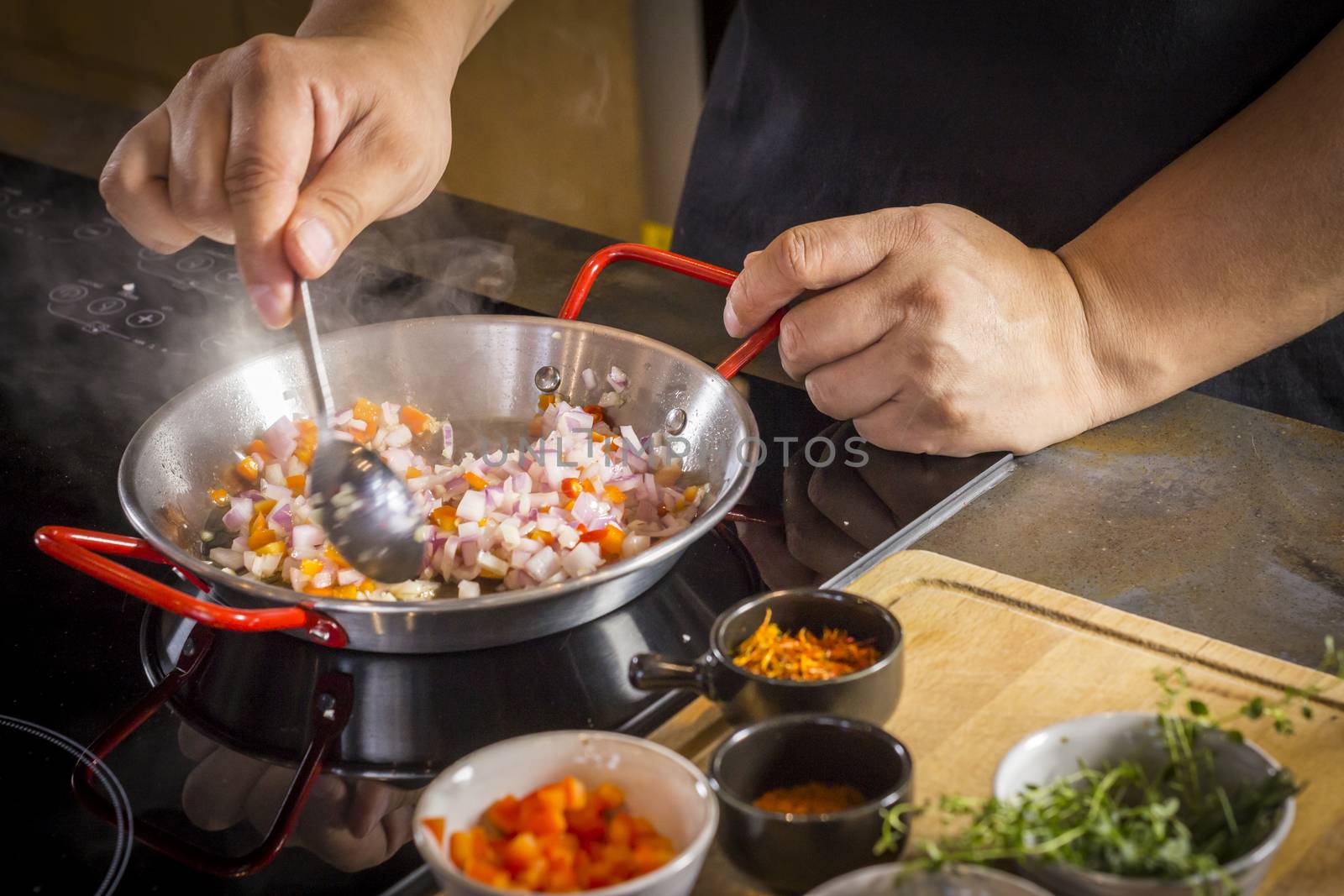 Chef is frying food ingredient for cooking paella.