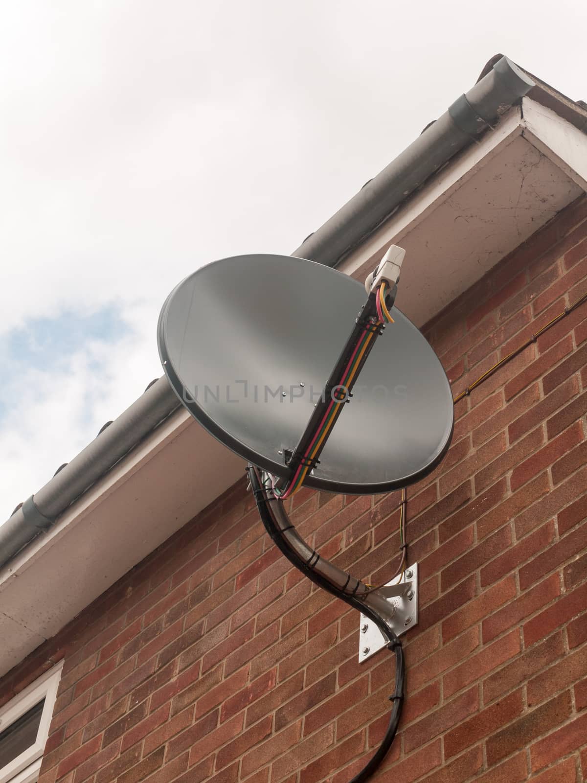 Stock Photo - a black sky dish satelite up close on brick wall by callumrc