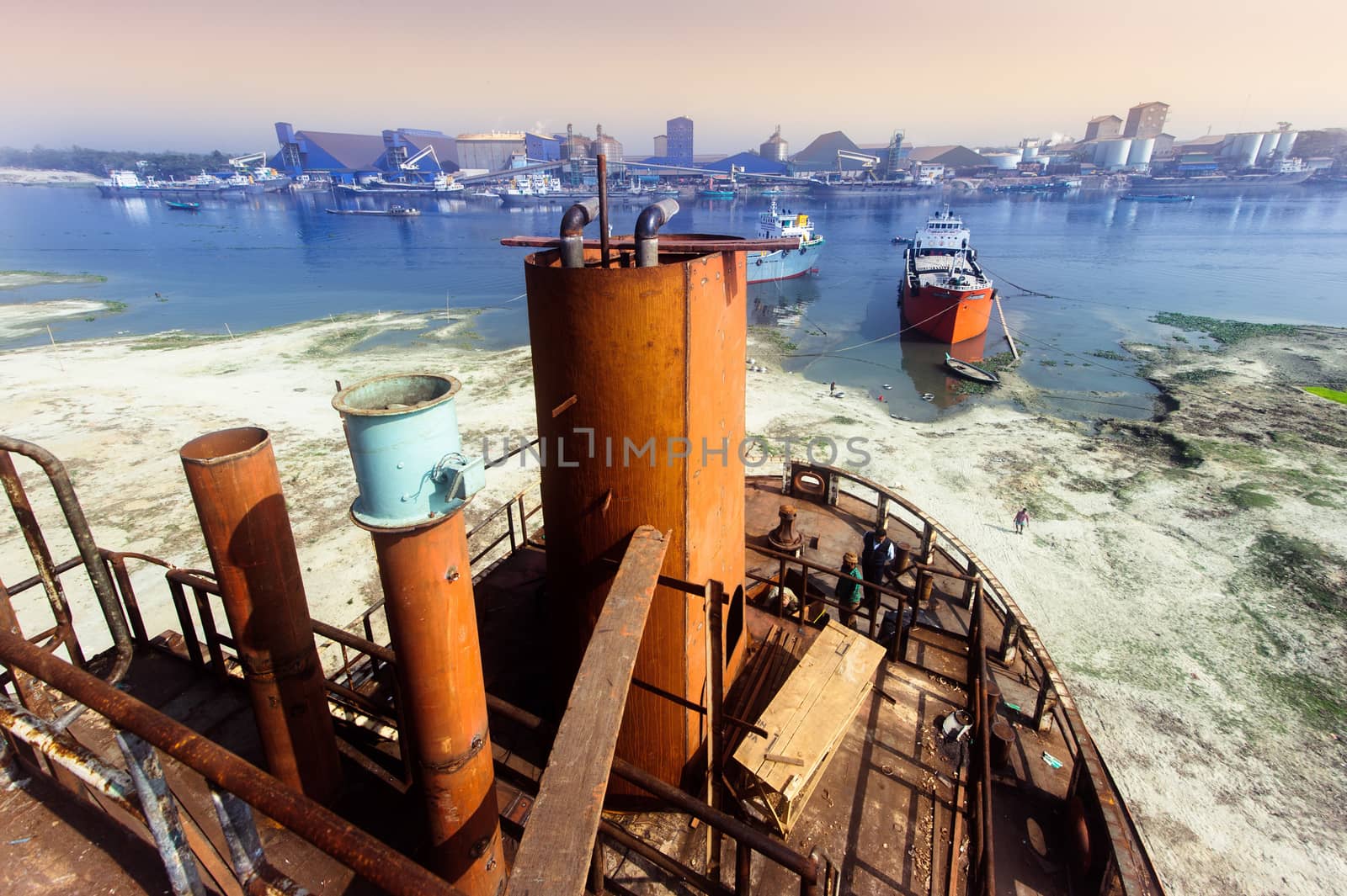 A large tanker ship is being renovated in shipyard