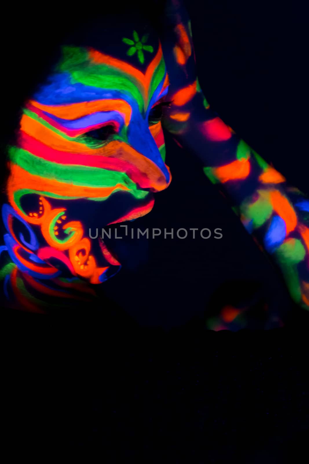 Woman with make up art of glowing UV fluorescent powder.