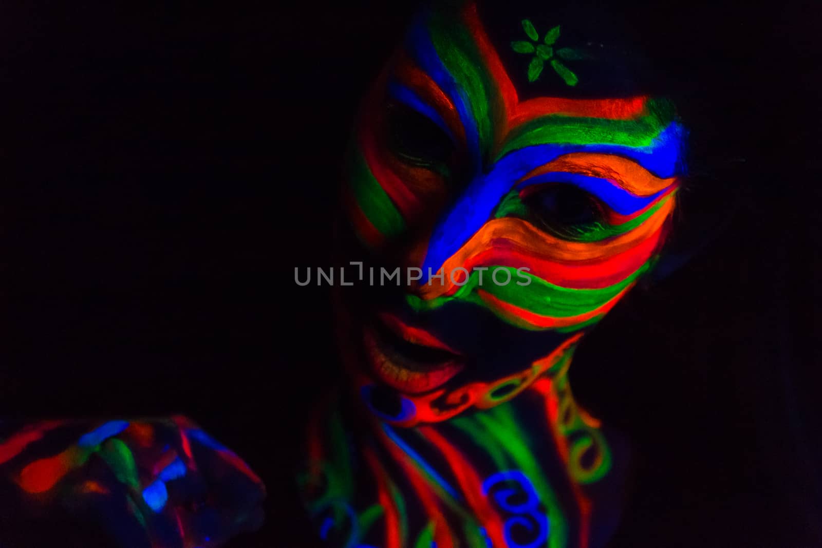 Woman with make up art of glowing UV fluorescent powder.