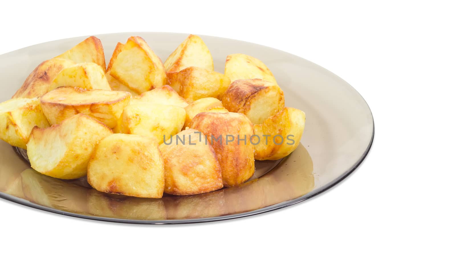 Fragment of the dark glass dish with country style fried potatoes on a light background
