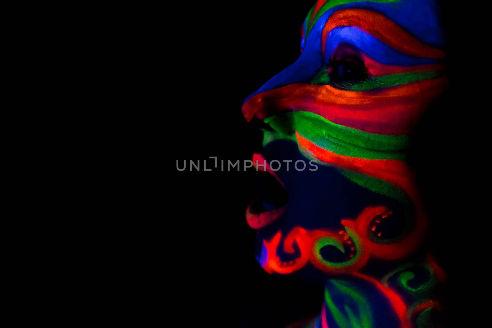 Woman with make up art of glowing UV fluorescent powder.