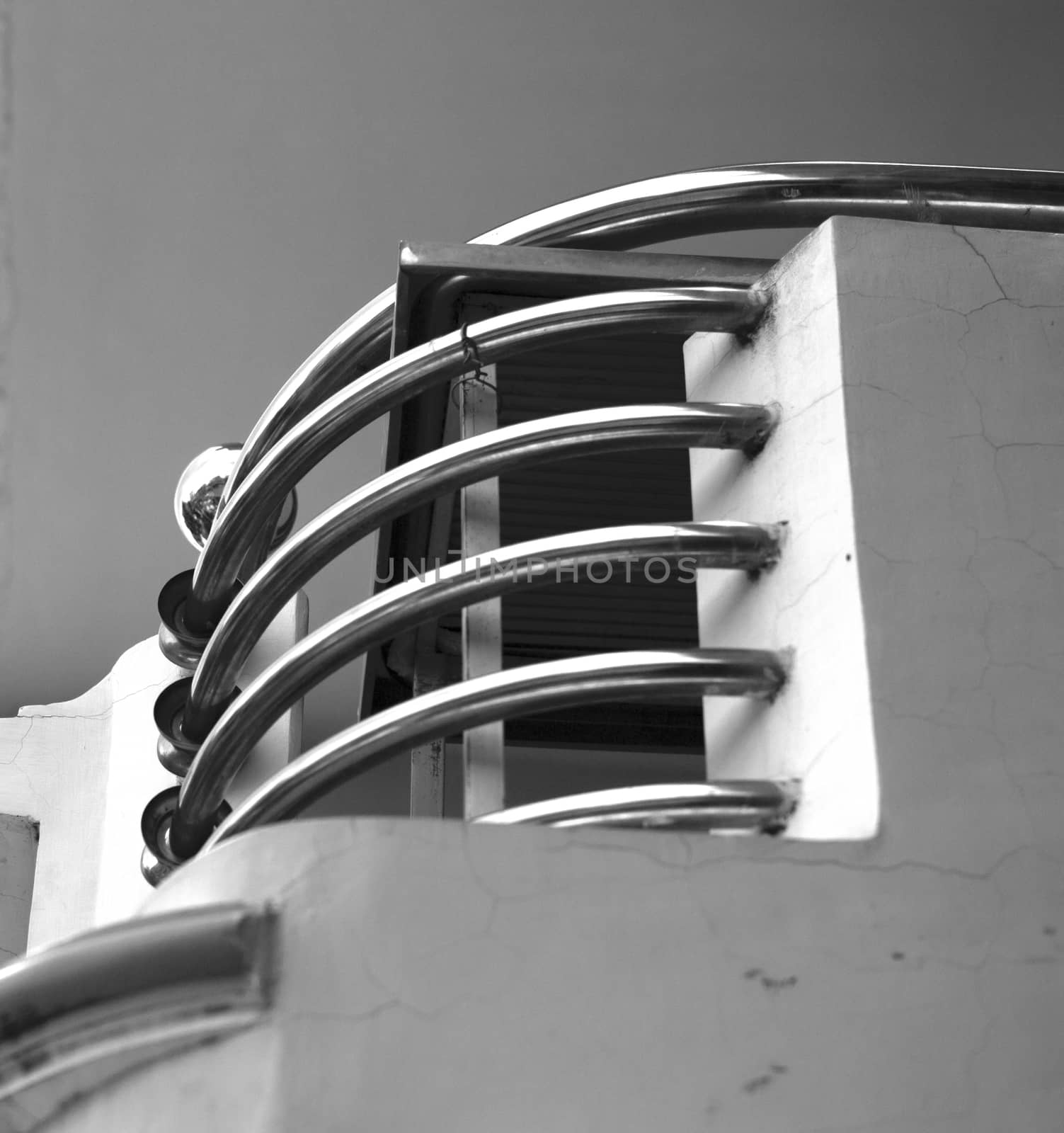 BLACK AND WHITE PHOTO OF CURVING STAINLESS STEEL HANDRAIL