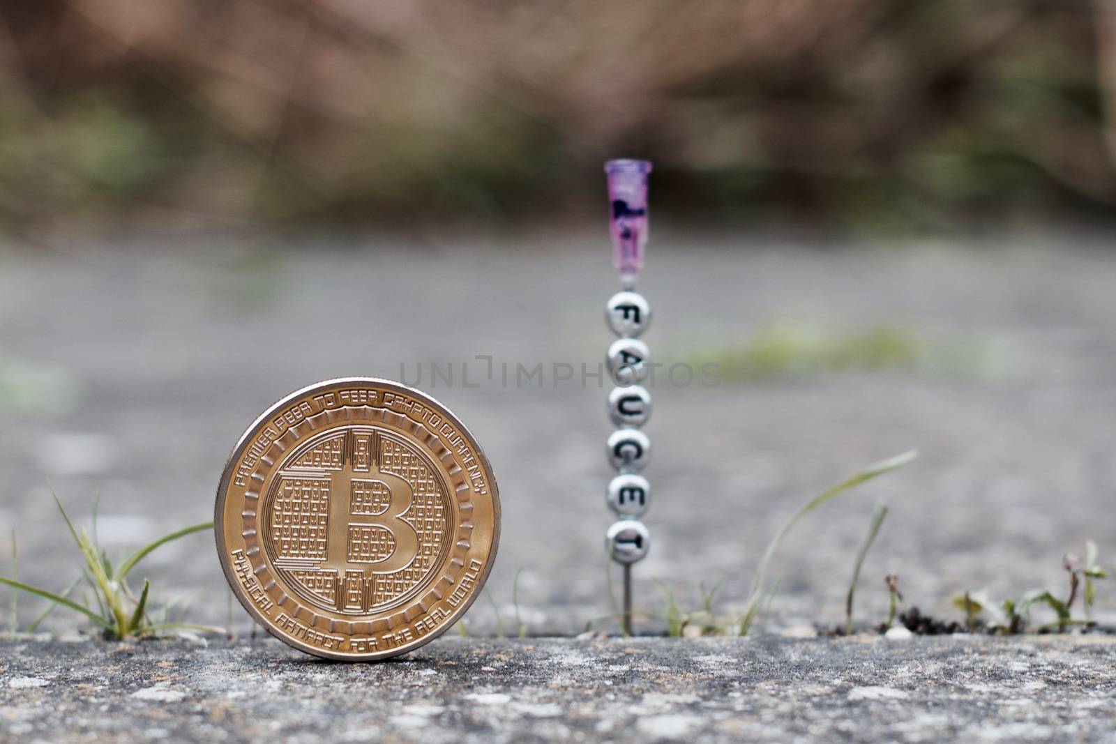 Digital currency physical gold bitcoin coin near faucet inscription on the needle.