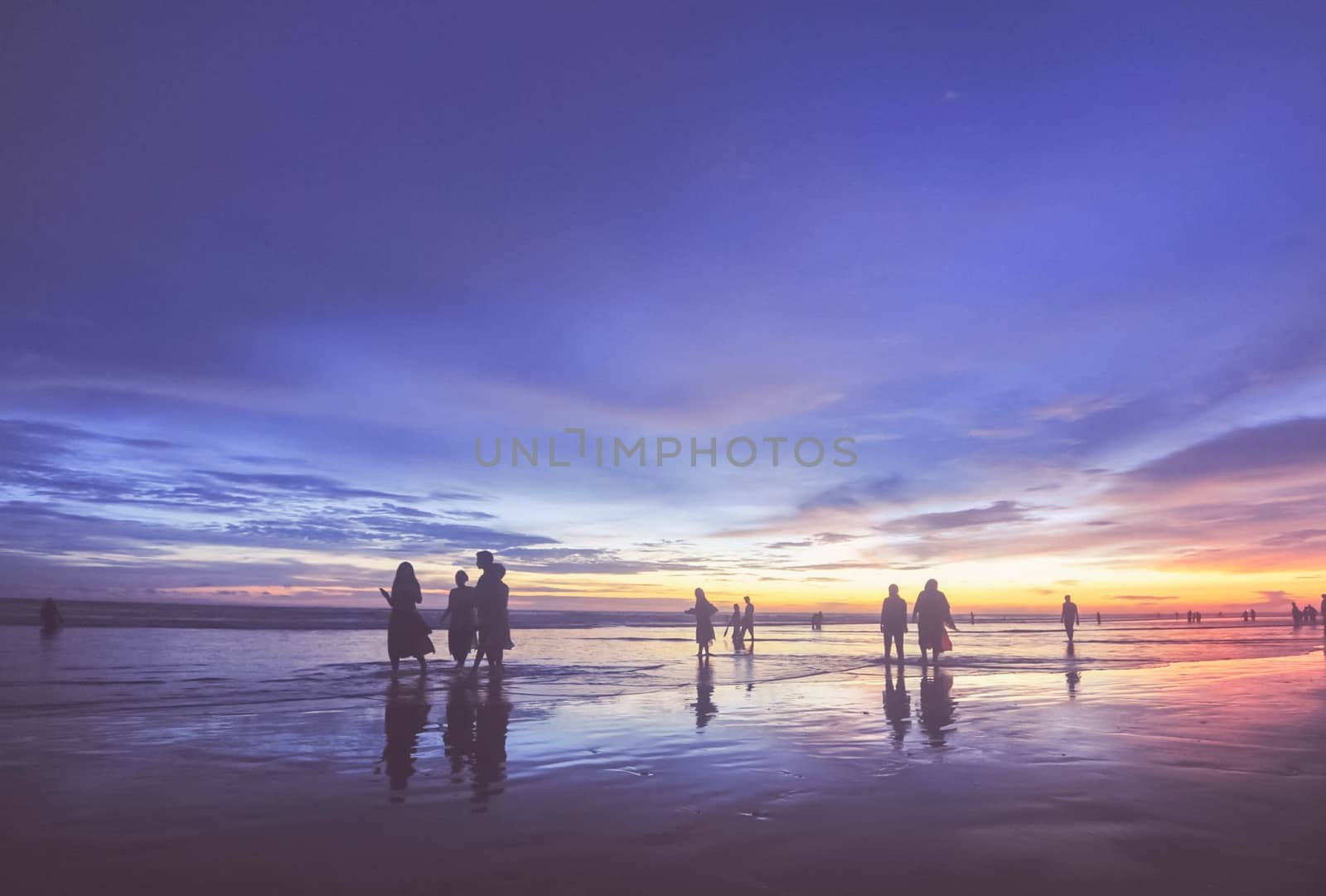 a group of peope are swimming in sea beach
