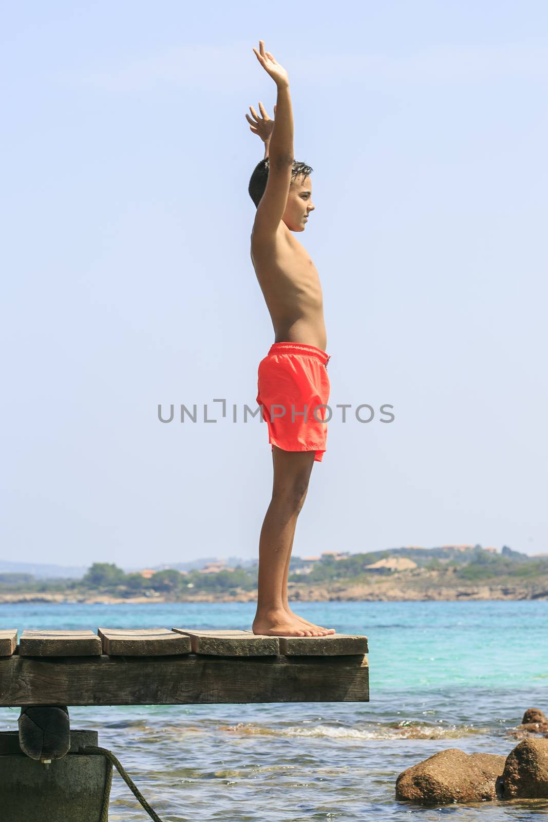 Boy in a Wooden pier on the mediterranean sea