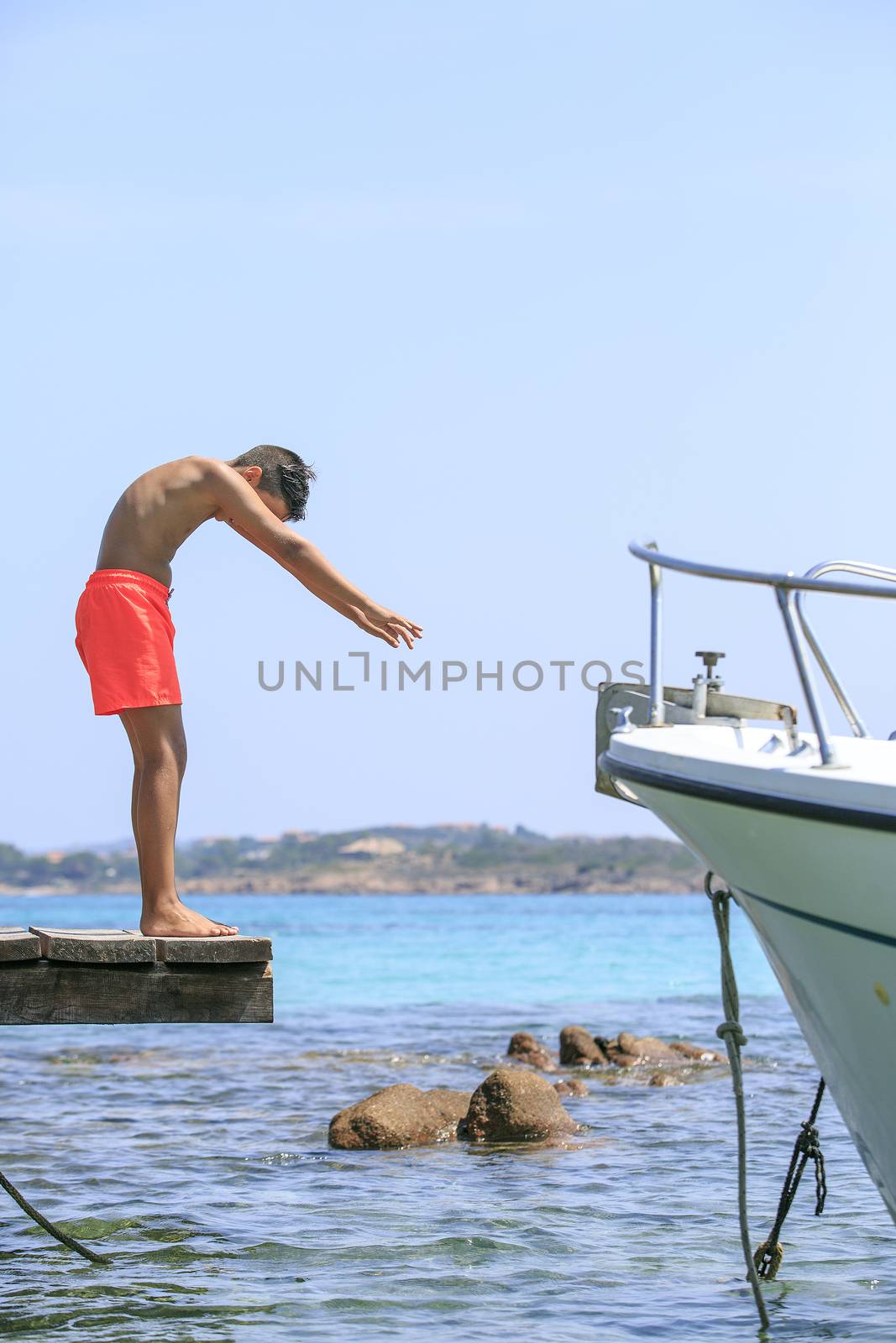 Boy in a Wooden pier on the mediterranean sea