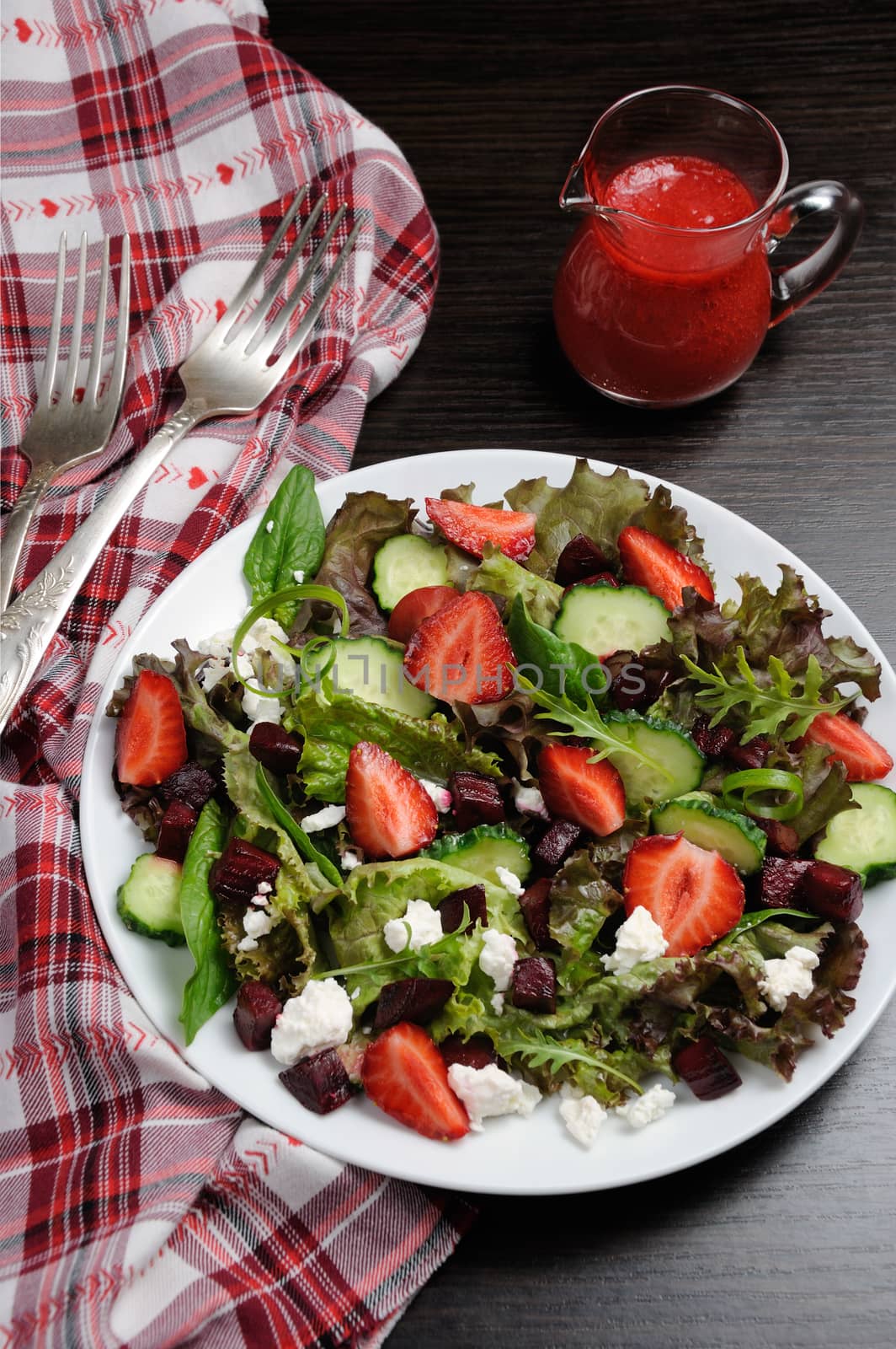 Salad of vinaigrette with strawberries, tender feta and strawberry sauce. Vertical shot.
