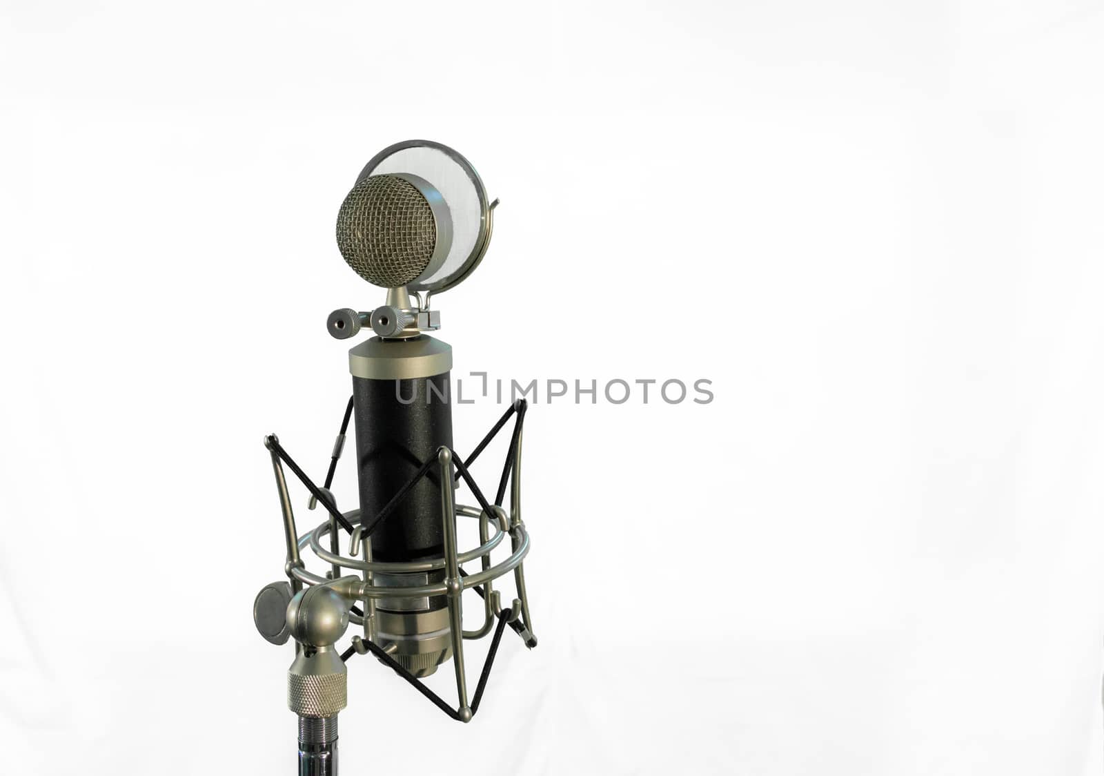 Vocal condenser microphone with wind screen isolated on white background.
